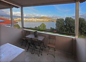 a balcony with a table and chairs and a view of the water at Swan Lake Front Apartment in Kastoria