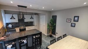 a kitchen with a counter and a table and chairs at Modernised 4 Bedroom Property Close To City Centre, Harehills Lane in Roundhay