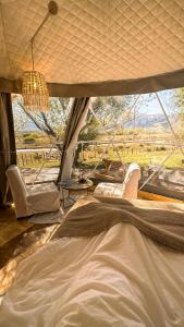 a bedroom with a bed and a large window at Glamping Tafí del valle in Tafí del Valle