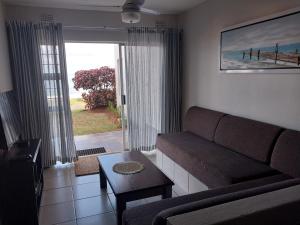 - un salon avec un canapé et une table dans l'établissement Illovo Views Holiday Apartment, à Kingsborough