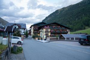 un grand bâtiment sur le côté d'une rue dans l'établissement Gästehaus -Pension Edelweiss, à Vent