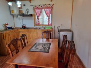 ein Holztisch und Stühle in einer Küche mit einem Tisch und einem Kühlschrank in der Unterkunft Mika's House 2 in Hanga Roa + 9 Fotos