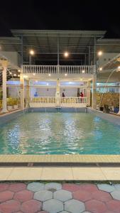 uma piscina com uma fonte à noite em Votel Hotel De'Pratnya Kediri em Kediri