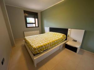 Un dormitorio con una cama con una manta amarilla. en piso estiu fabara, en Fabara