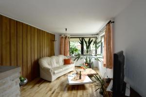 a living room with a white couch and a tv at Ferienwohnung Nessler in Radebeul