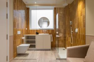 a bathroom with a toilet and a sink and a mirror at La Florida Suites by Olala Homes in Hospitalet de Llobregat
