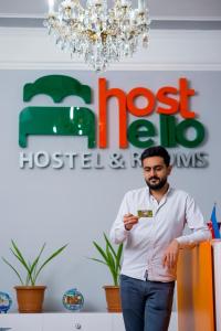 a man standing in front of a store holding a credit card at Hostello in Baku