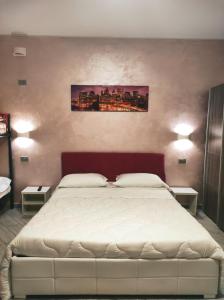 カルダーノ・アル・カンポにあるVilla Ormeniのベッドルーム(白い大型ベッド、ランプ2つ付)