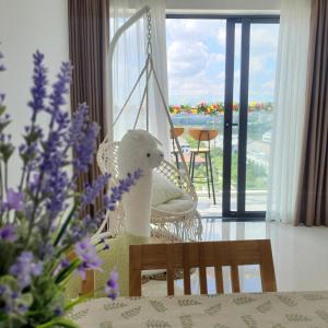 a room with a swing and a table with purple flowers at Mô Tê Huế Homestay in Hue