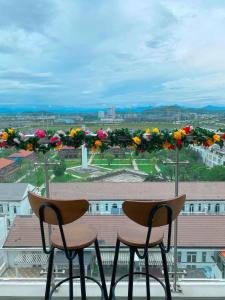 - deux chaises assises au-dessus d'un balcon fleuri dans l'établissement Mô Tê Huế Homestay, à Hue