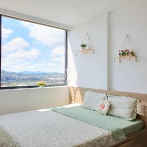 a bedroom with a bed with a large window at Mô Tê Huế Homestay in Hue