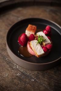 a plate of food with strawberries on a table at Posthorn in Ühlingen-Birkendorf