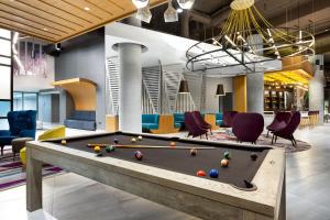 a billiard room with a pool table and chairs at Aloft San Juan in San Juan