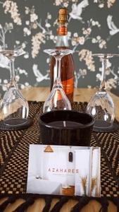 a bottle of wine and two glasses on a table at Azahares Apartamento turístico in El Bosque