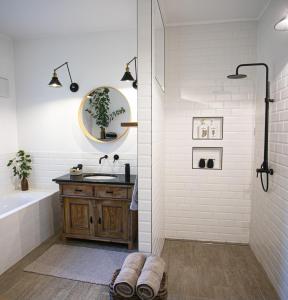 a bathroom with a tub and a sink and a mirror at Cozy Airport in Vecsés