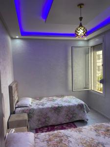 1 dormitorio con 2 camas y una iluminación púrpura en holiday and beach self check-in en Agadir