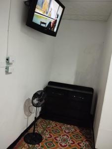 Habitación con tocador negro y TV en la pared. en Hotel Colonial Armenia RO en Armenia