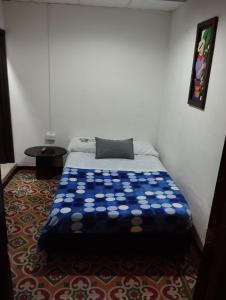 Una cama en una habitación con una cubierta azul. en Hotel Colonial Armenia RO en Armenia