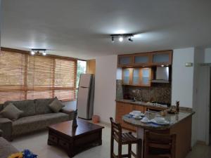 cocina y sala de estar con sofá y mesa en apartosuite Sabana Grande en Caracas