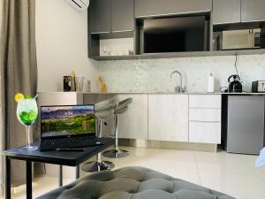 a kitchen with a laptop on a table with a wine glass at Essence Lifestyle Self-Catering Accommodation in Windhoek