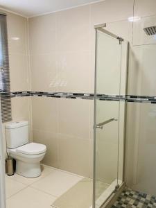 a bathroom with a toilet and a glass shower at Essence Lifestyle Self-Catering Accommodation in Windhoek