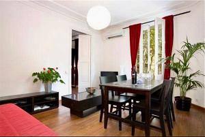 una sala de estar con mesa de comedor y una habitación con sofá rojo. en 5-bed apartment in the heart of the city en Barcelona
