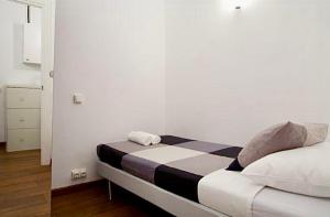 1 dormitorio con 1 cama en una habitación blanca en 5-bed apartment in the heart of the city en Barcelona