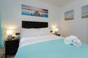 ein Schlafzimmer mit einem Bett mit zwei Handtüchern darauf in der Unterkunft Eastney Escape in Portsmouth