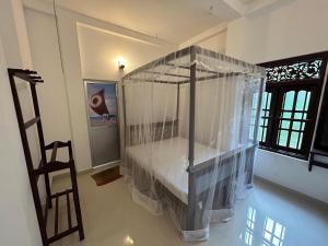 a room with a bed with nets on it at Gstar Home Stay in Ahangama