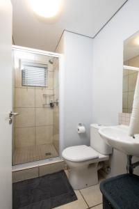 a bathroom with a shower and a toilet and a sink at Lux Garden Ballito Groves 1101 in Ballito