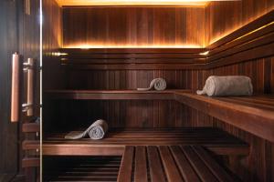 a sauna with wooden walls and wooden shelves with towels at The Beach Tulum Hotel in Tulum