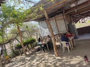 a group of people sitting at tables in a patio at Hospedaje los polos in Villavieja