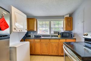 uma cozinha com armários de madeira e um frigorífico branco em Charming Lexington Home - 2 Mi to Downtown! em Lexington