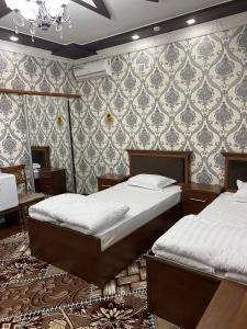 a bedroom with two beds and a wall at VOSTOK HOTEL in Bukhara +38 photos