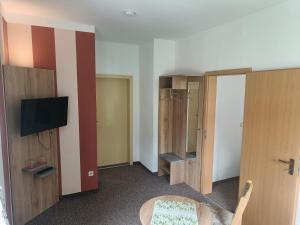 a room with a tv and some wooden cabinets at Zur Edlen Krone in Neuhausen