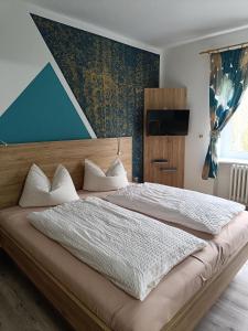 ein Schlafzimmer mit einem großen Bett mit blauer Wand in der Unterkunft Zur Edlen Krone in Neuhausen