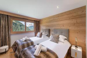 シャテルにあるBlack Diamond - Chalet - BO Immobilier- remises sur les forfaits de skis Châtel ou Portes du soleilの木製の壁と窓のある部屋にベッドが2つある