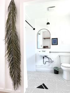 a bathroom with a sink and a palm tree at Triangle Motel in Red Bluff