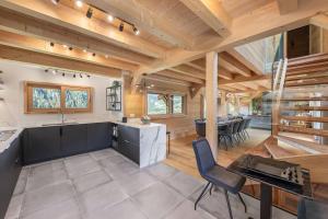 シャテルにあるBlack Diamond - Chalet - BO Immobilier- remises sur les forfaits de skis Châtel ou Portes du soleilのピアノのあるオープンキッチンとダイニングルーム
