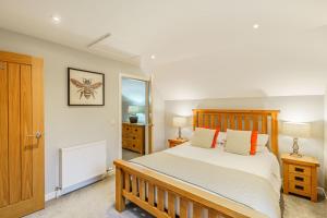 a bedroom with a wooden bed and two night stands at Lord Galloway 36 with Hot Tub in Newton Stewart