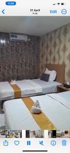 a hotel room with two beds at Votel Hotel De'Pratnya Kediri in Kediri