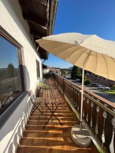 a patio with an umbrella and benches on a balcony at Helle Wohnung mit großem Balkon in Oberreute