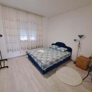 um quarto com uma cama e uma grande janela em Knežević apartman 