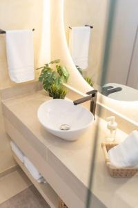a bathroom with a white sink and a mirror at Presidential Studio with Gated Parking at Casas Sanblu in Ensenada +22 photos