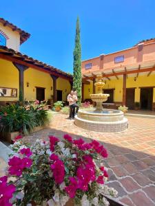 a man standing in front of a courtyard with a fountain at Casa Colonial San Alejo in Lemos