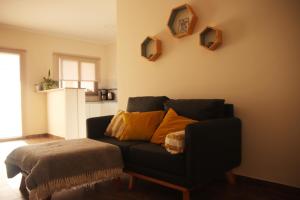 una sala de estar con un sofá negro con almohadas amarillas en Complejo Vista Tres Picos en Sierra de la Ventana