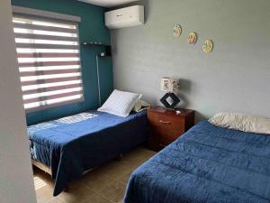 a bedroom with two twin beds and a window at Casa Deluxe Celaya in Celaya
