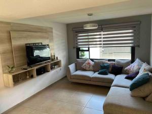 a living room with a couch and a tv at Casa Deluxe Celaya in Celaya