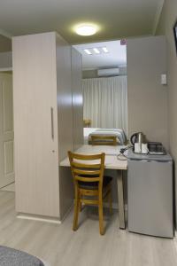 uma cozinha com uma mesa e uma cadeira num quarto em The Suburban Guest House em Bloemfontein