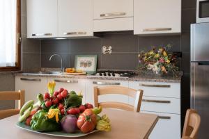 a plate of fruits and vegetables on a table in a kitchen at Residence Oleandro in Pietra Ligure